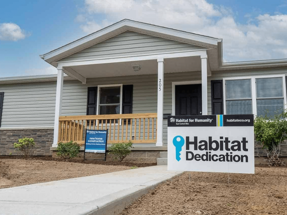 Volunteers planting native shrubs at a Habitat for Humanity home—join the movement to beautify communities and support pollinators with your garden expertise.